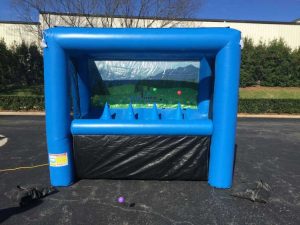 Picture of Archery Ball inflatable. The inflatable is blue with a backdrop of a green field. In front of the backdrop are four blue cone shaped funnels that each have a plastic colored ball hovering over them.