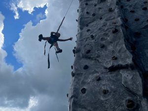 Picture of an elementary age student repelling down a mobile rock climbing wall.